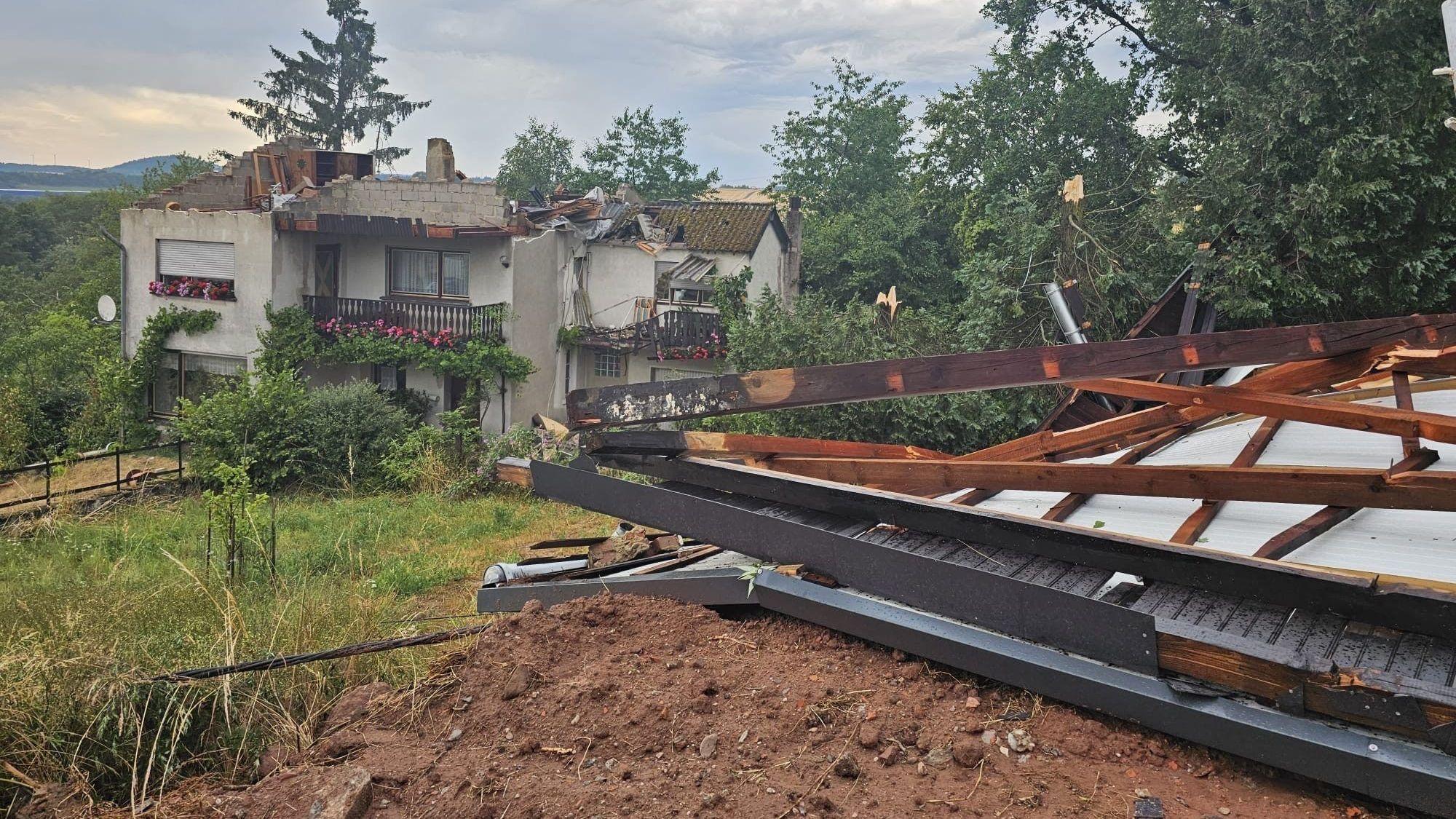 Ein Blick auf stark beschädigte Hausdächer nach einem Unwetter in Asweiler der saarländischen Gemeinde Freisen im Landkreis St. Wendel.