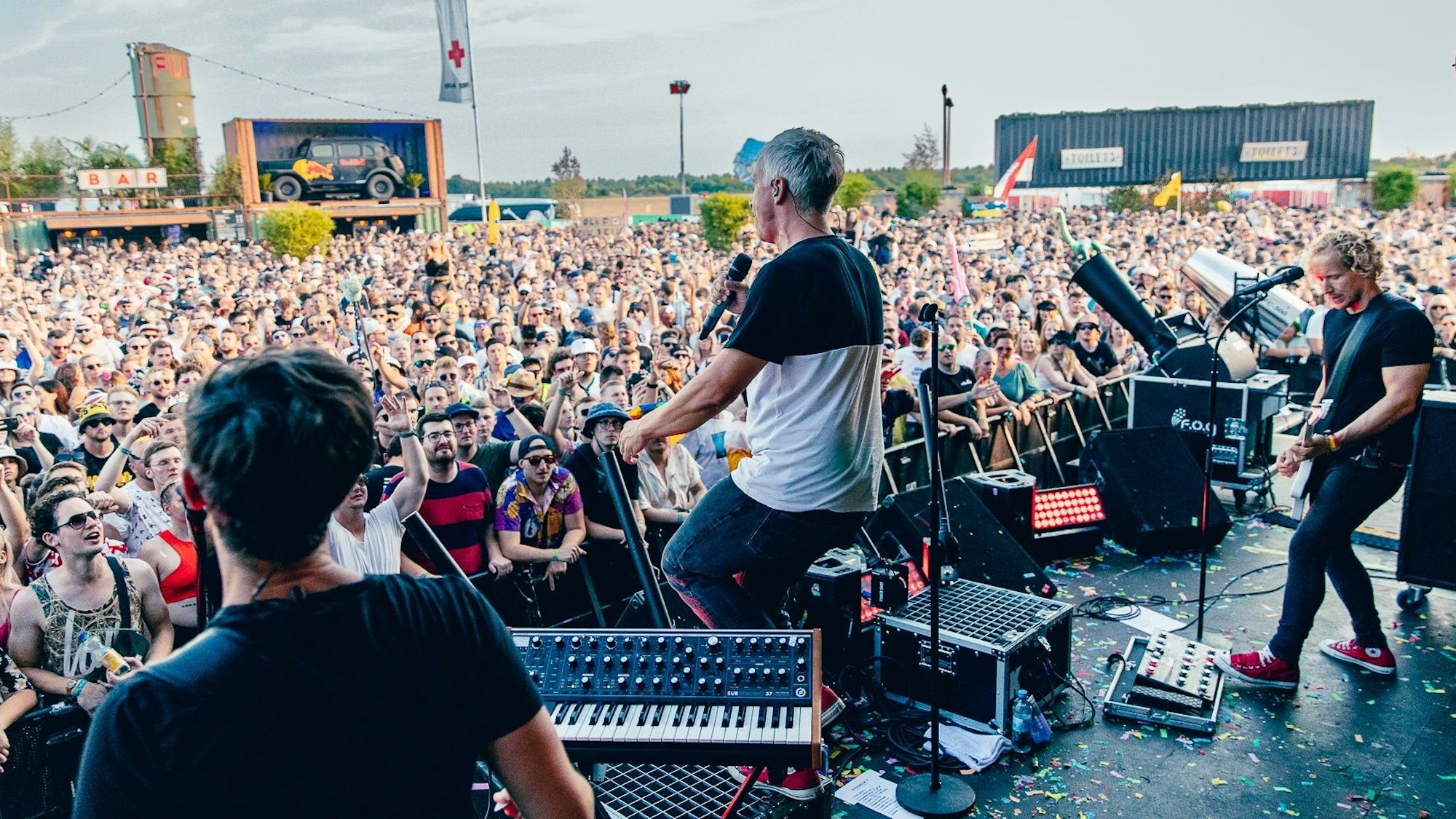 Zu sehen ist die Kölner Band Kasalla im Jahr 2022 auf einer Bühne beim Parookaville-Festival. Davor befindet sich eine Menschenmasse.
