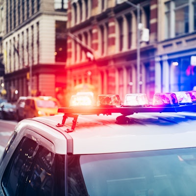 Polizeiauto mit Sirene und Blaulicht auf dem Dach eilt zu einem Notruf in New York City.