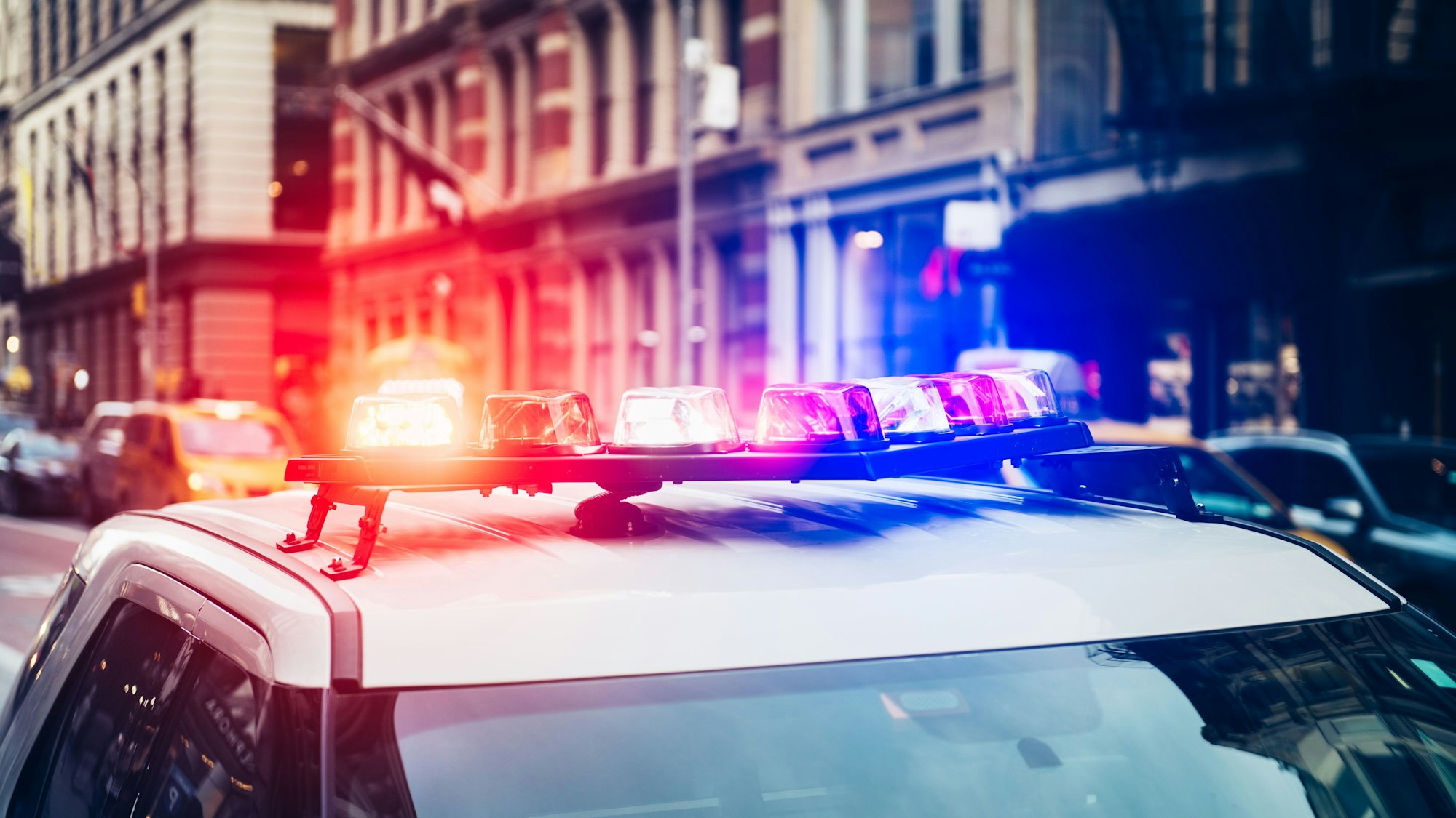 Polizeiauto mit Sirene und Blaulicht auf dem Dach eilt zu einem Notruf in New York City.