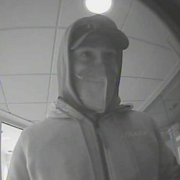Das Bild zeigt einen Mann mit Kapuzenpulli und Basecap, der von der Überwachungskamera der Bank gefilmt wurde.