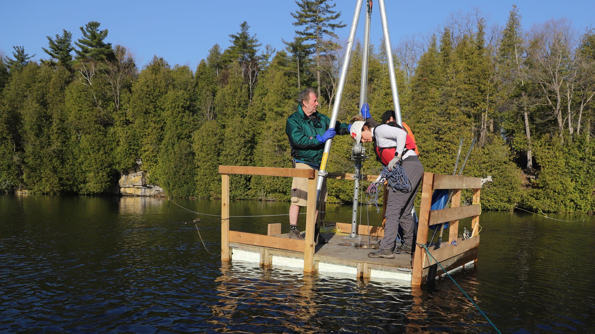 Die Wissenschaftler Tim Patterson (l), Carling Walsh und Zack Milani (hinten) bereiten sich auf die Entnahme der Sedimentprobe vom Grund des Crawford Lake vor.