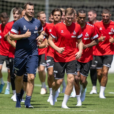 Profis des 1. FC Köln beim Lauftraining auf dem Fußballplatz.