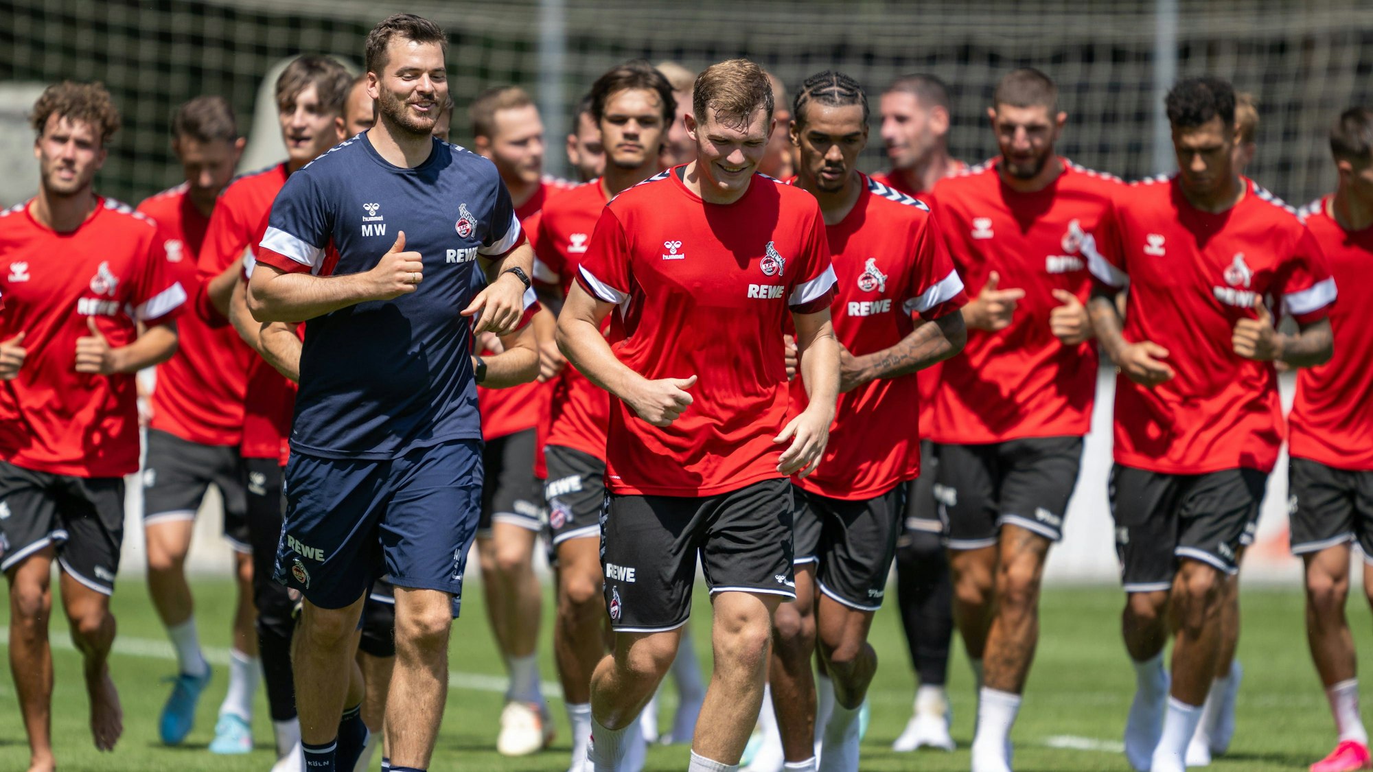 Profis des 1. FC Köln beim Lauftraining auf dem Fußballplatz.