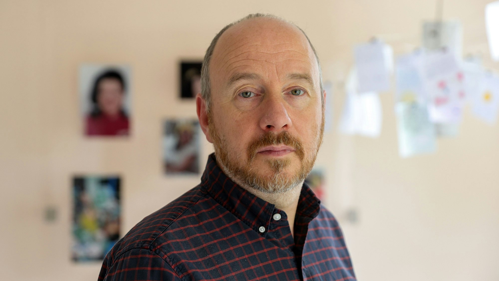 Knappstein trägt ein kariertes dunkles Hemd und einen Bart.