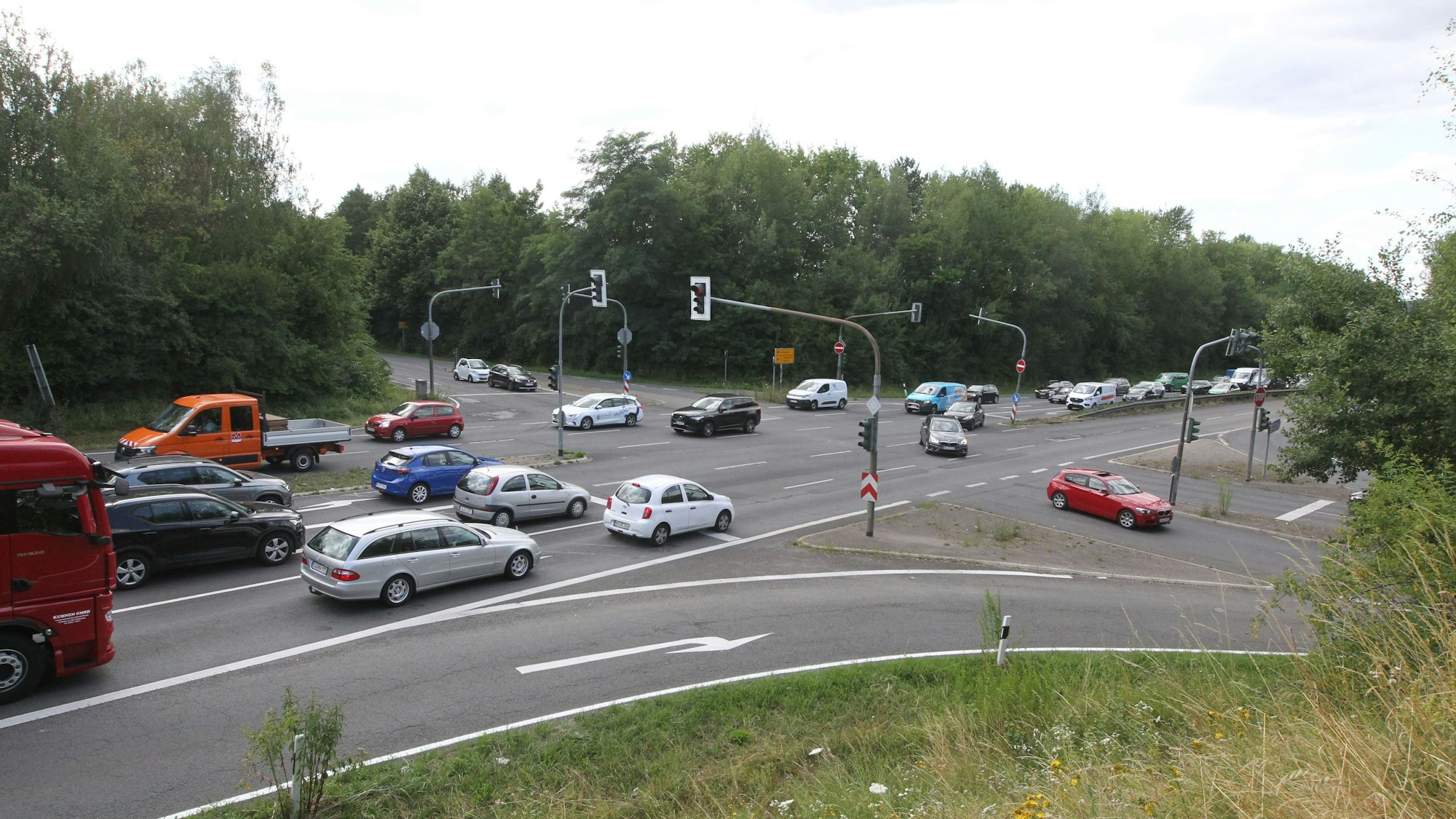 Ein Blick auf die Ampelkreuzung mit vielen Autos und zwei Lastwagen.