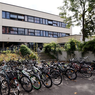 Vor einem Schulgebäude stehen viele Fahrräder.