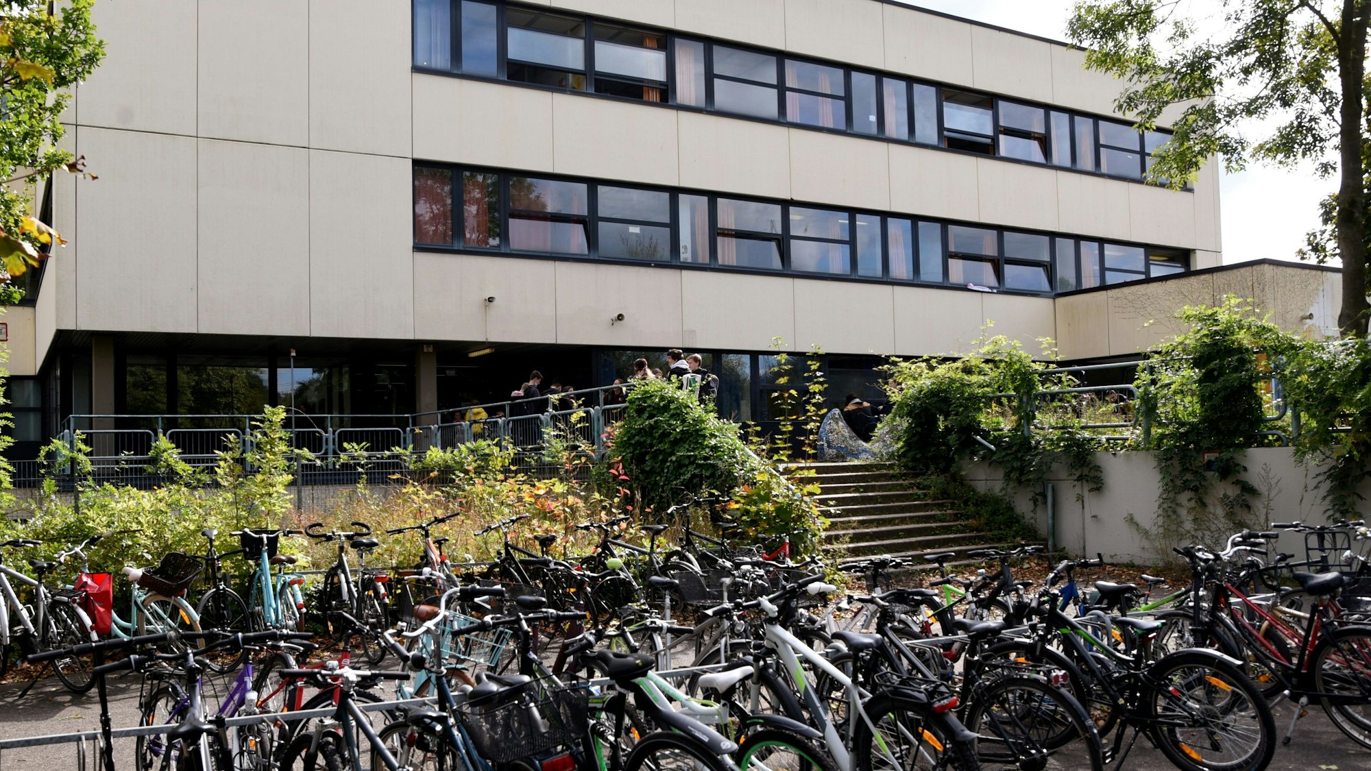 Vor einem Schulgebäude stehen viele Fahrräder.