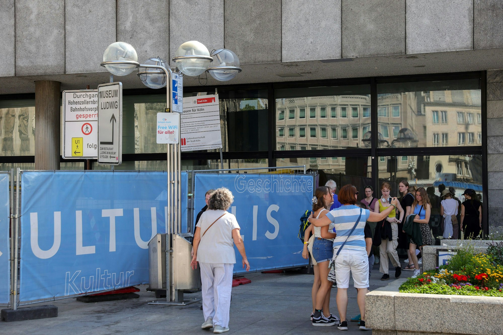 Menschen am Gatter zum gesperrten Durchgang zum Museum Ludwig am geschlossenen Römisch-Germanischen Museum