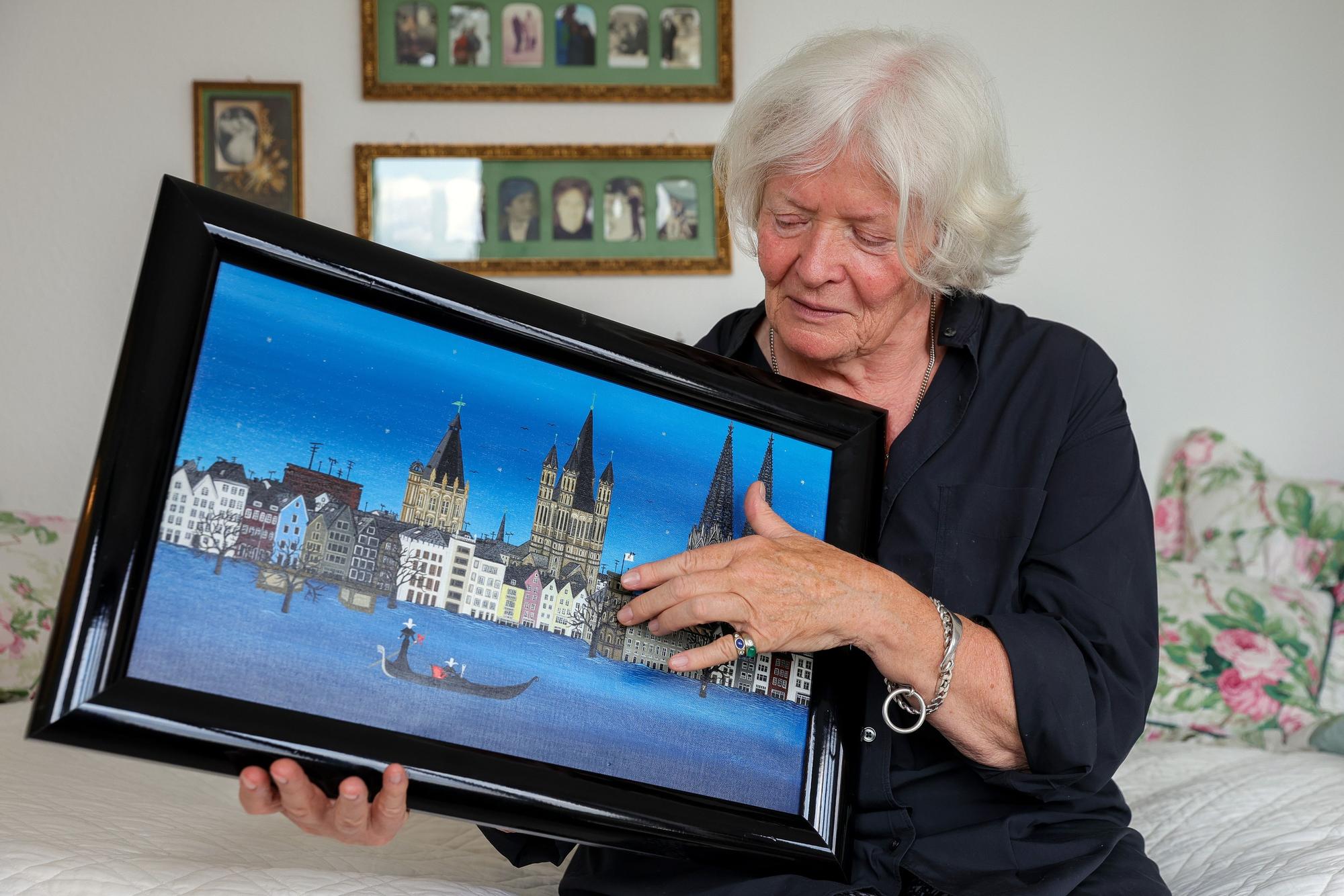 Eine Frau hält ein Bild mit Rheinpanorama in die Kamera.