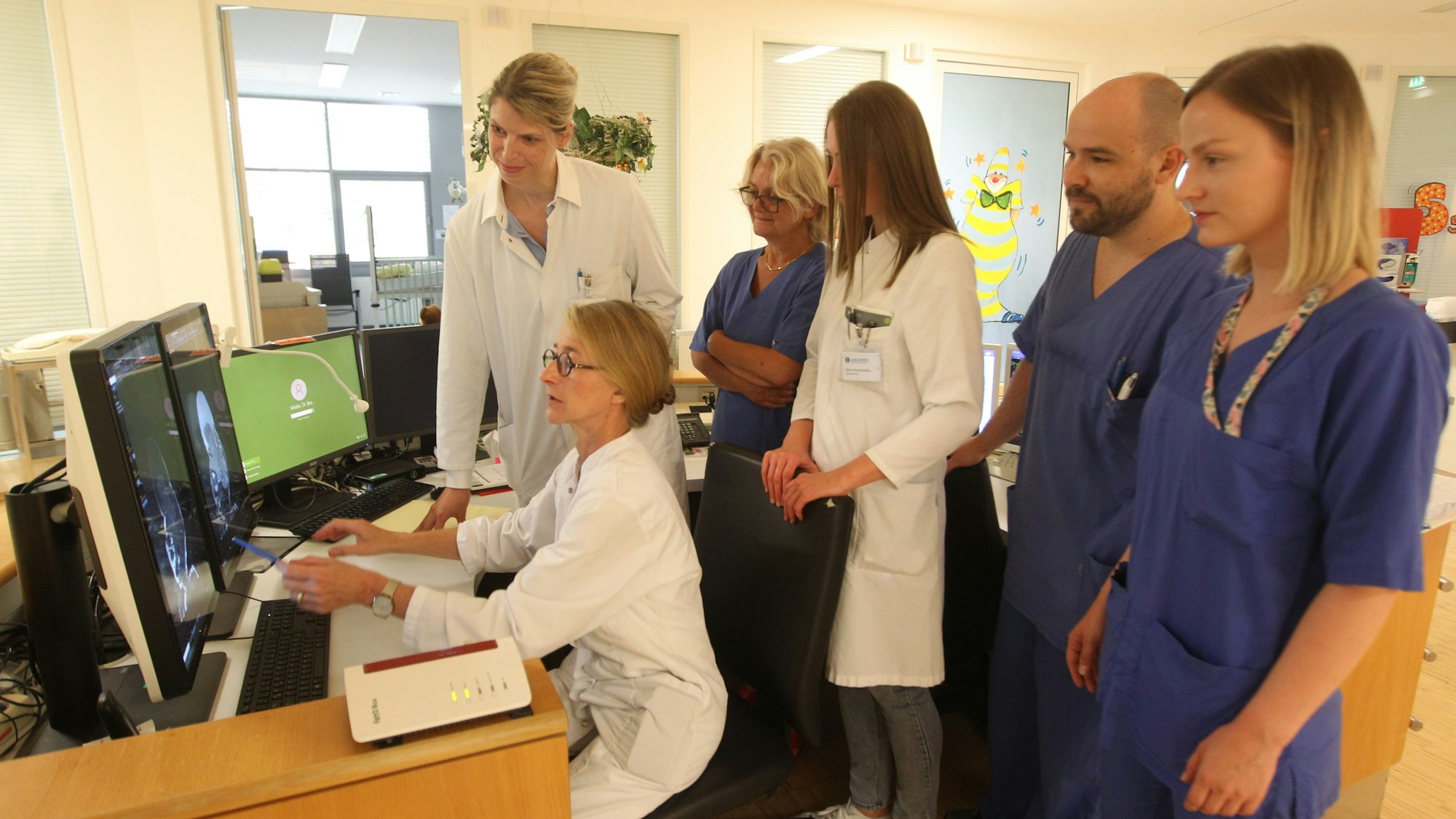 Frühbesprechung auf der Intensivstation: Professorin Martina Messing-Jünger (sitzend), Leitende Oberärztin Dr. Ann Kristin Schmitz (3.v.r. ) und Chefärztin Dr. Beatrix Wiebe (4.v.r).