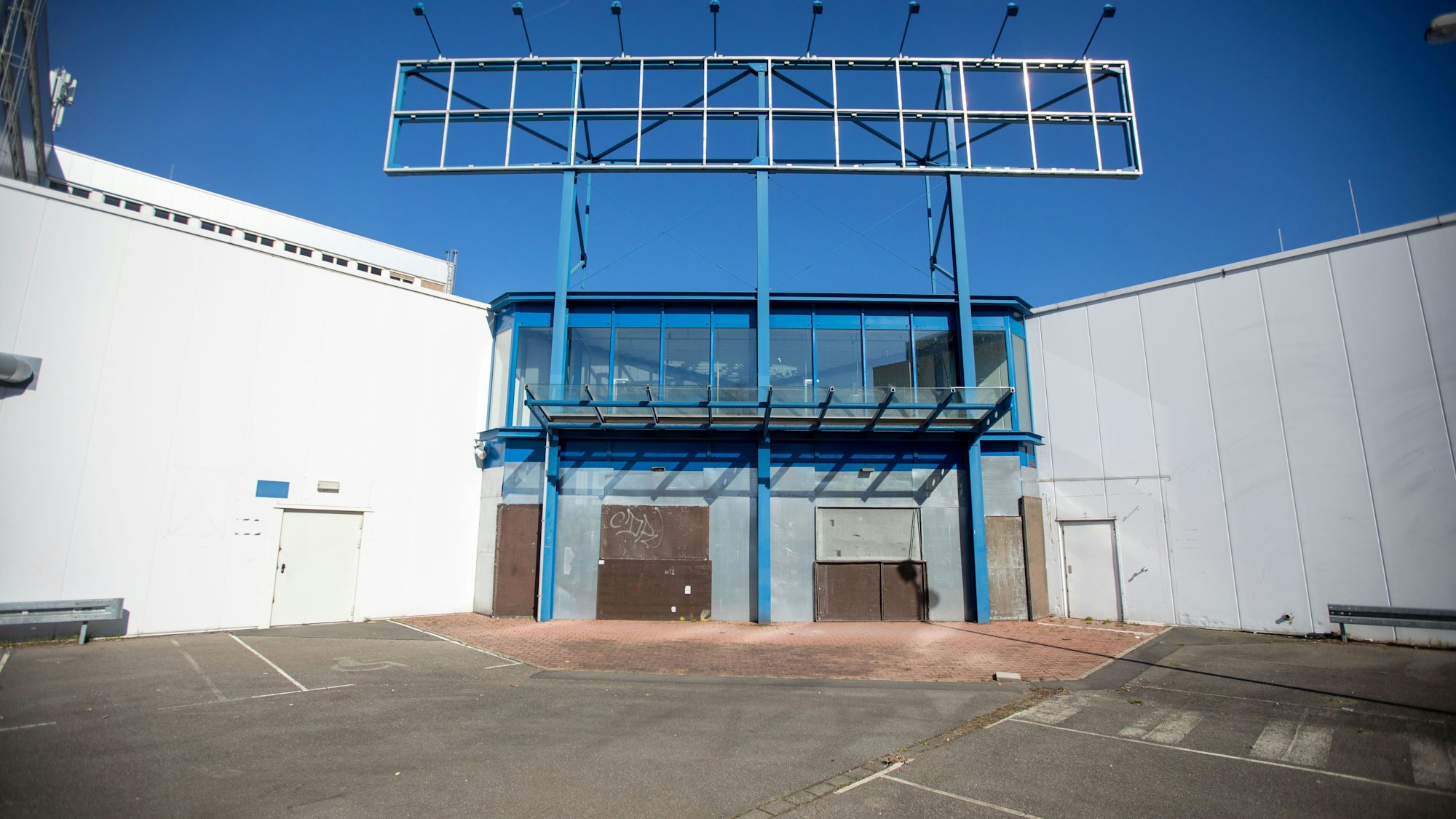 Der Haupteingang des ehemaligen Baumarkts mit verbarrikadierten Türen ist zu sehen.