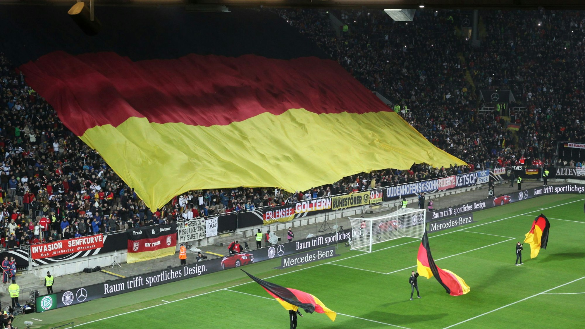 Die Fans halten vor Spielbeginn eine große Deutschlandflagge über ihren Köpfen.