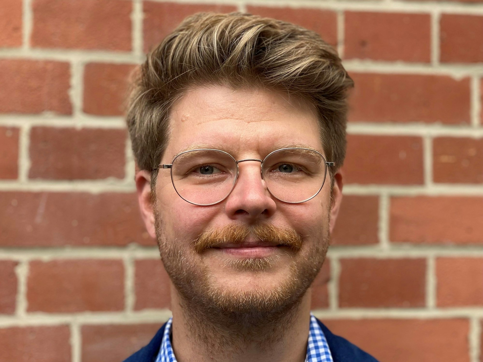 Sebastian Baer-Henney ist einer der Pfarrpersonen bei der Pop-Up-Hochzeit an der Kölner Christuskirche. Er lächelt in die Kamera.