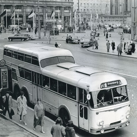 Ein Bus vom Typ Büssing/Ludewig TU 7 Eineinhalbdecker mit dem Fahrtziel Gremberg wartet 1961 auf der Trankgasse am Hauptbahnhof. Das Bild zeigt den Bus in schwarz weiß.