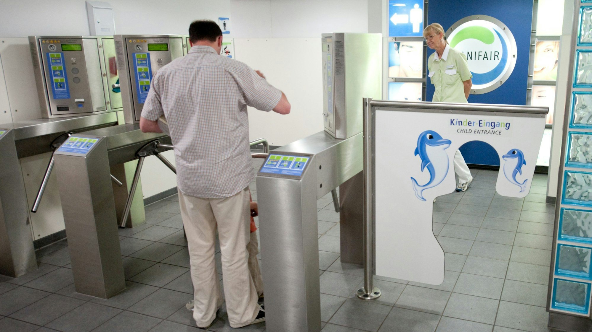 Ein Kunde bezahlt die Benutzung des Toilettenbereichs in einer Autobahnraststätte.