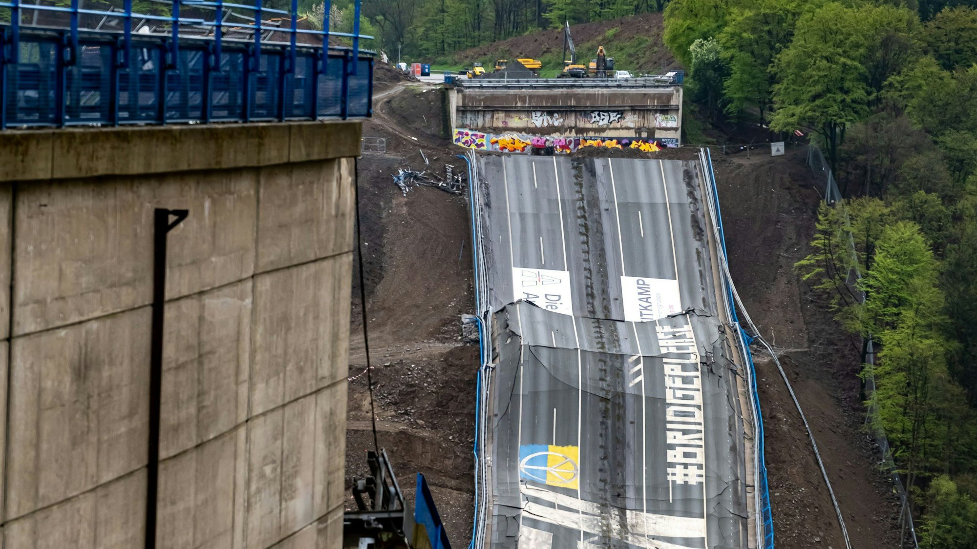 Nach der Sprengung liegt die Rahmede-Talbrücke am Boden, Teile der Fahrbahn sind zu sehen.