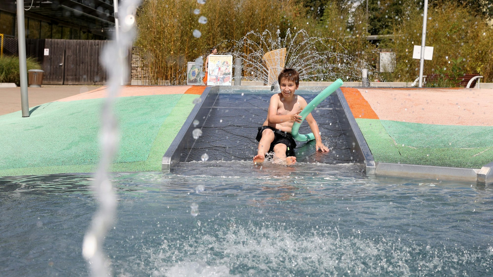 Ein Junge spielt im Kinderbereich im Lentpark Freibad in Köln.