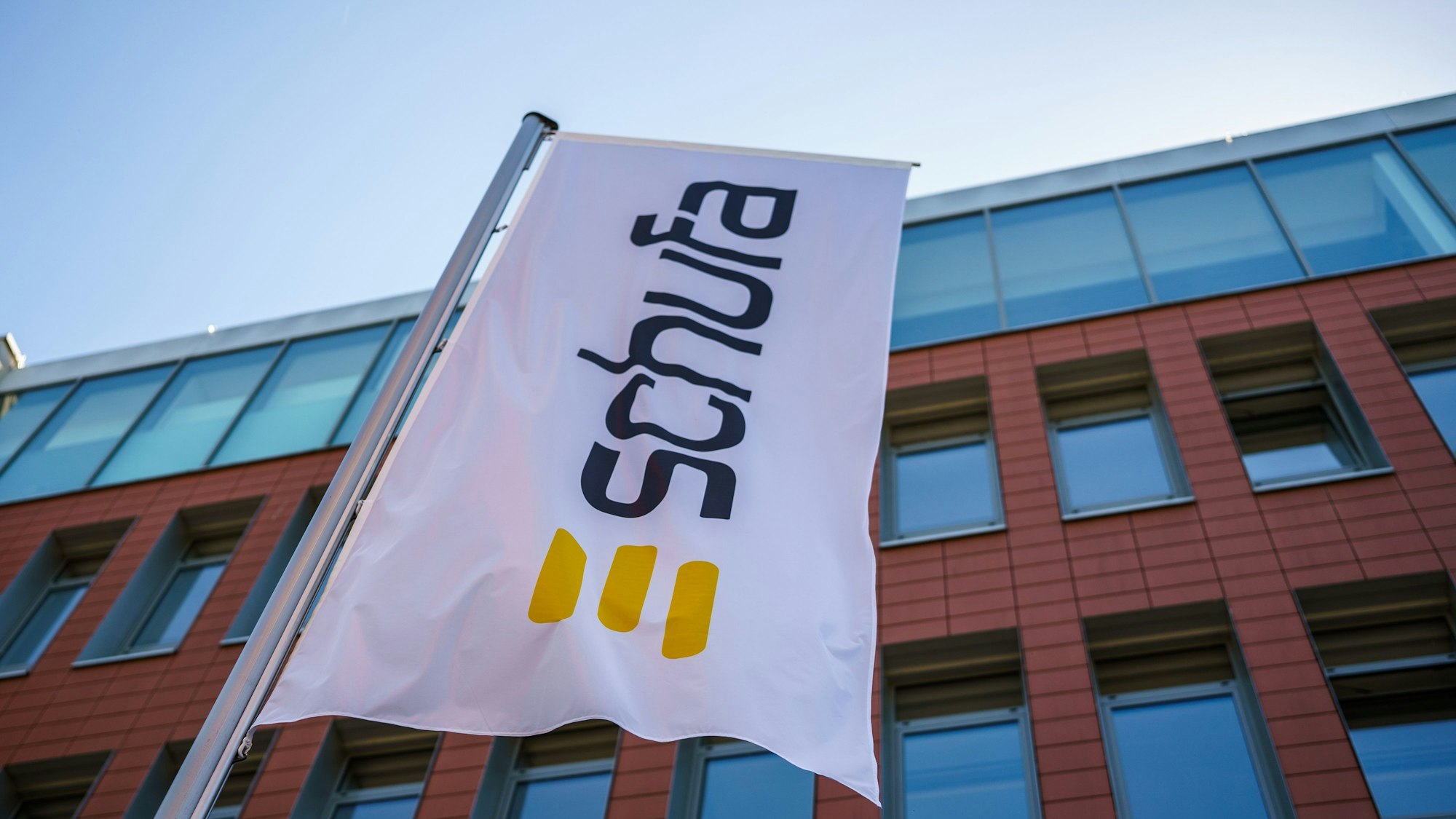 Eine Flagge mit dem Firmenlogo flattert vor dem Geschäftssitz in Wiesbaden.