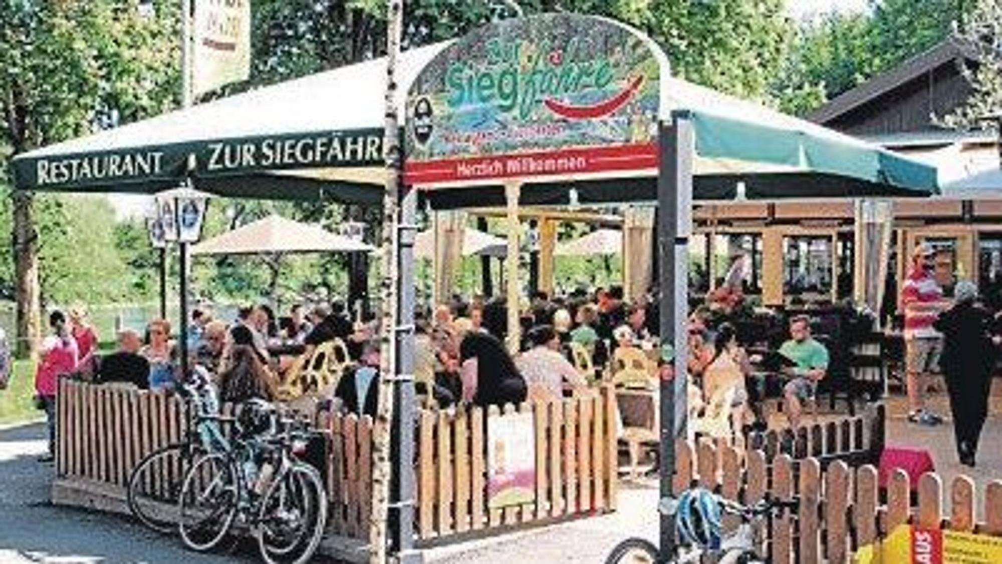 Menschen sitzen in einem Biergarten.
