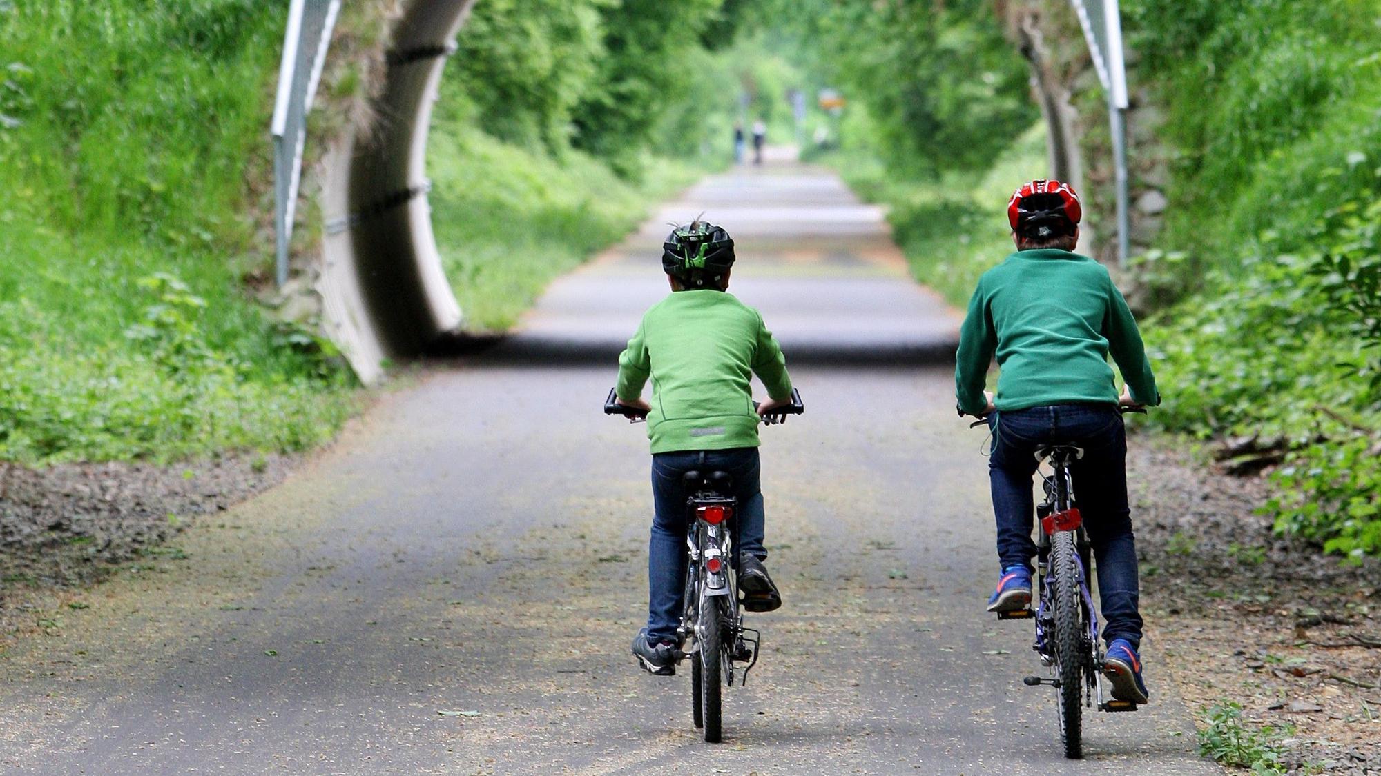Zwei Kinder fahren Fahrrad.