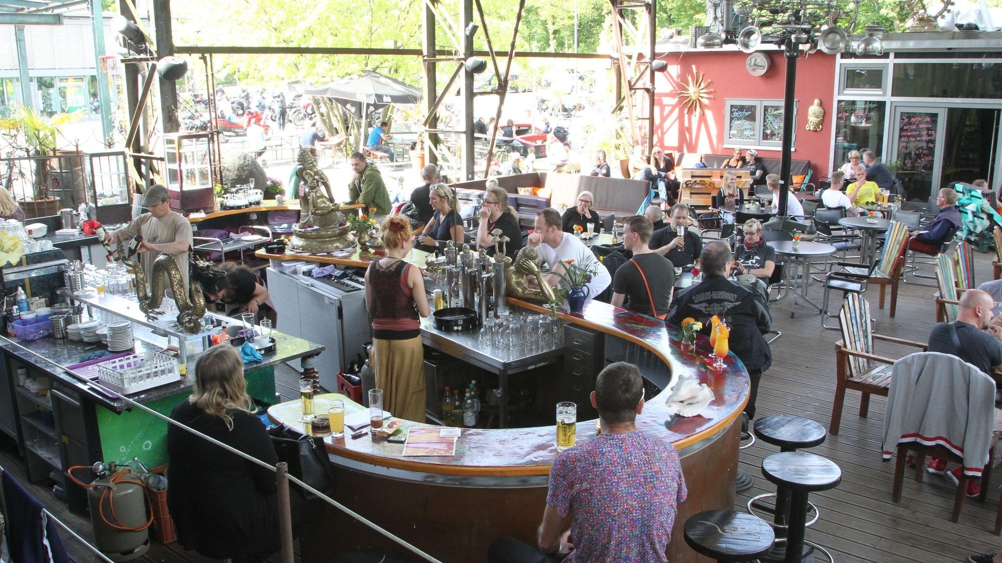 Menschen sitzen in einem Biergarten.