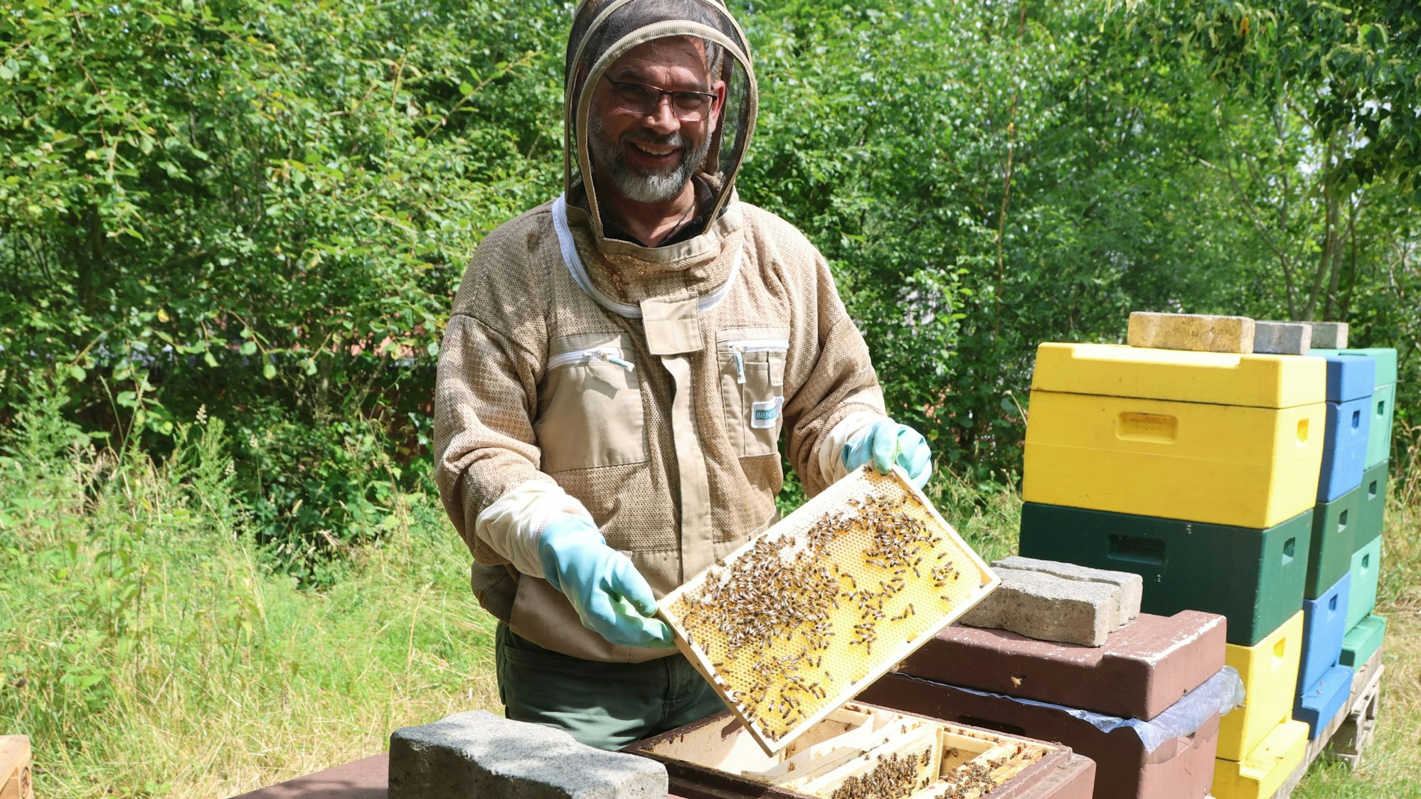 Imker Bernd-Uwe Eggers-Thomas an seinen Bienenstöcken.