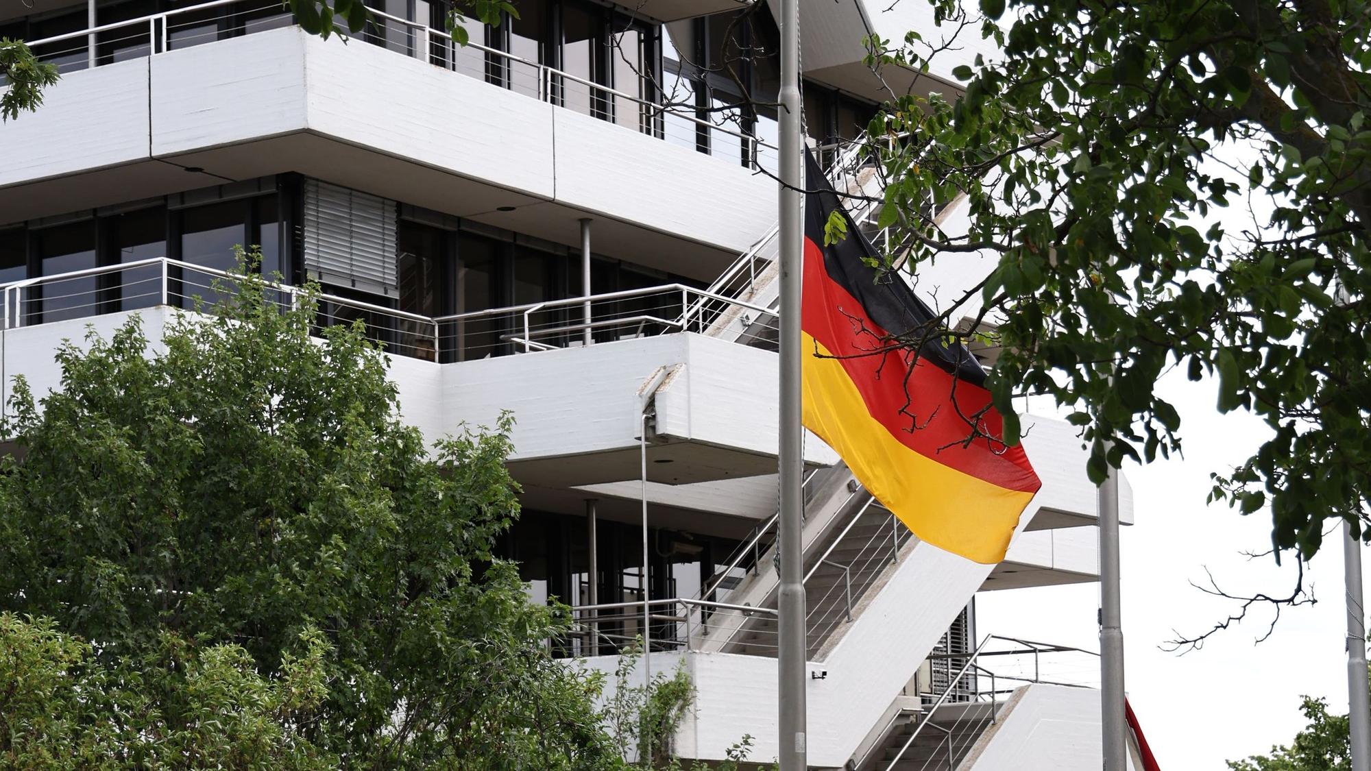 Eine Deutschlandflagge weht an einem Fahnenmast, im Hintergrund ist das Euskirchener Kreishaus zu sehen.