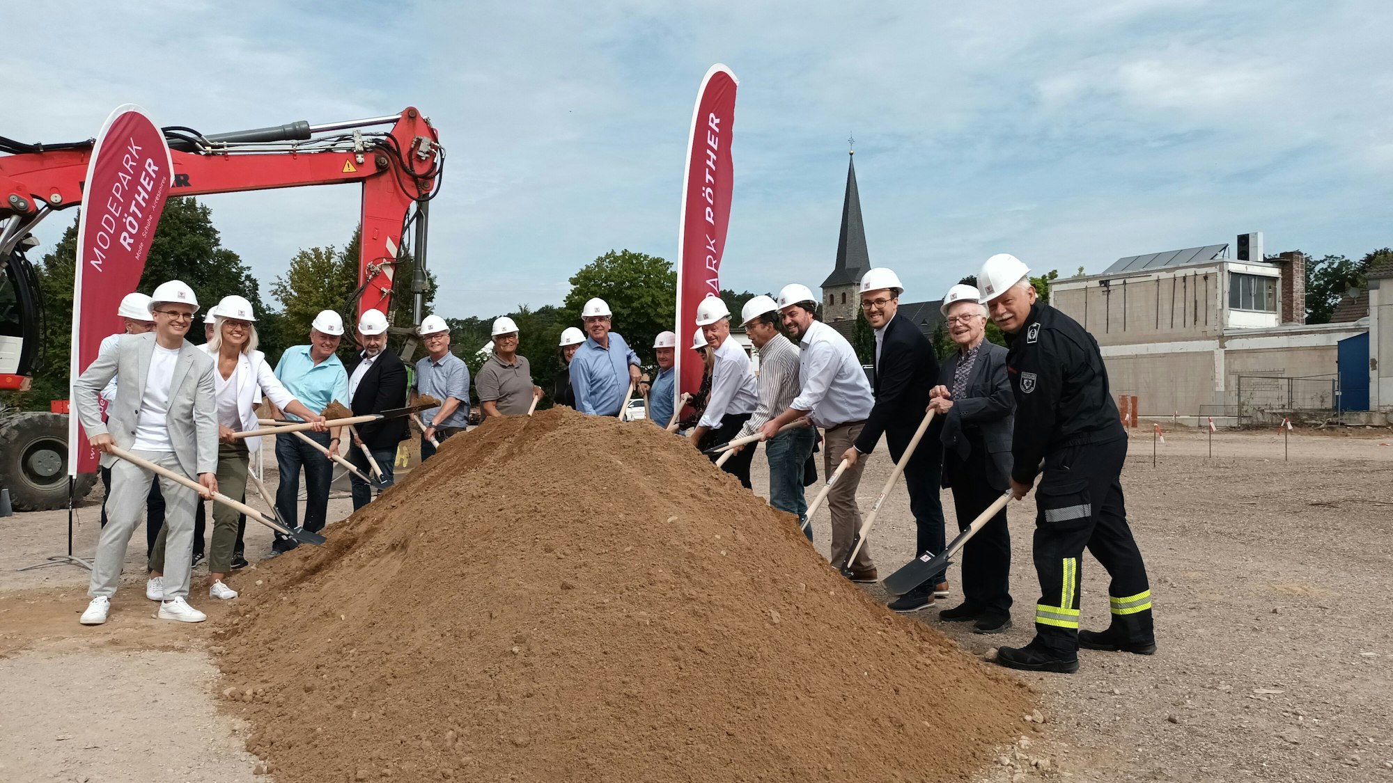 Viele Personen beim Spatenstich eines Gebäudes.