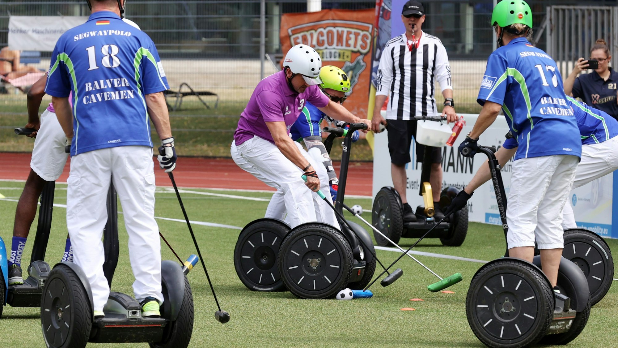 Zu sehen sind Teilnehmer der Zehnten Weltmeisterschaft im Segway-Polo auf der Ostkampfbahn im Müngersdorfer Sportpark. Der Spieler mit dem violetten Shirt ist Werner Ludwig von den Lohmarer Funky-Turtles.