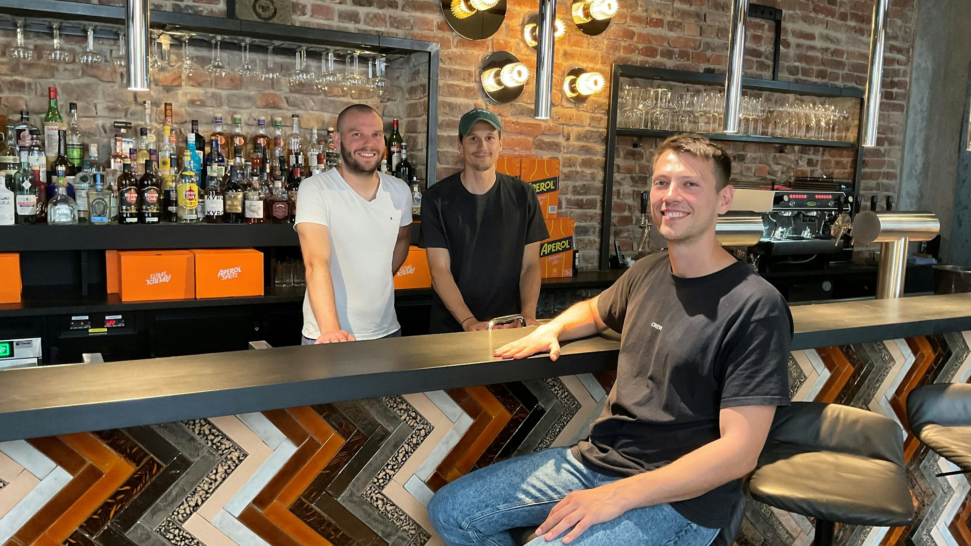 Drei junge Männer an einer Bar