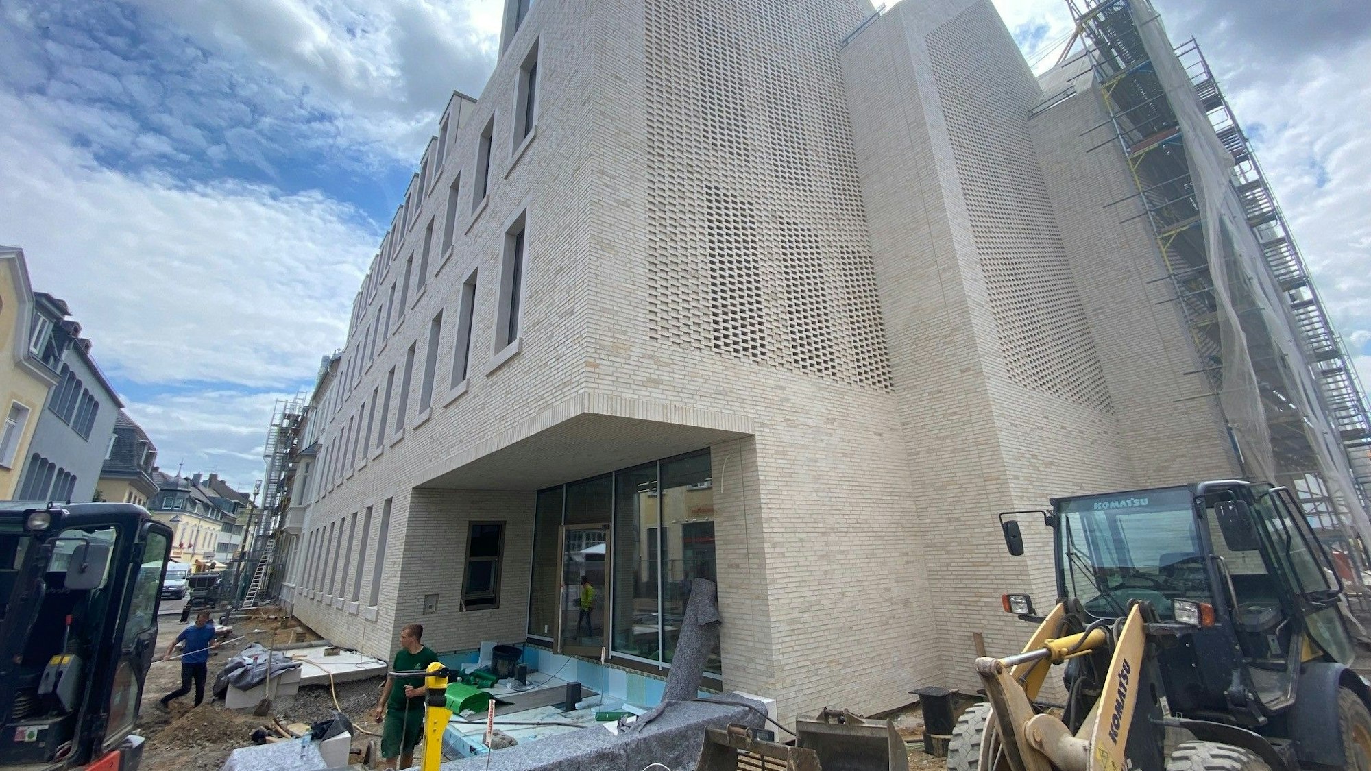 Vor einem Gebäude ist eine Baustelle.