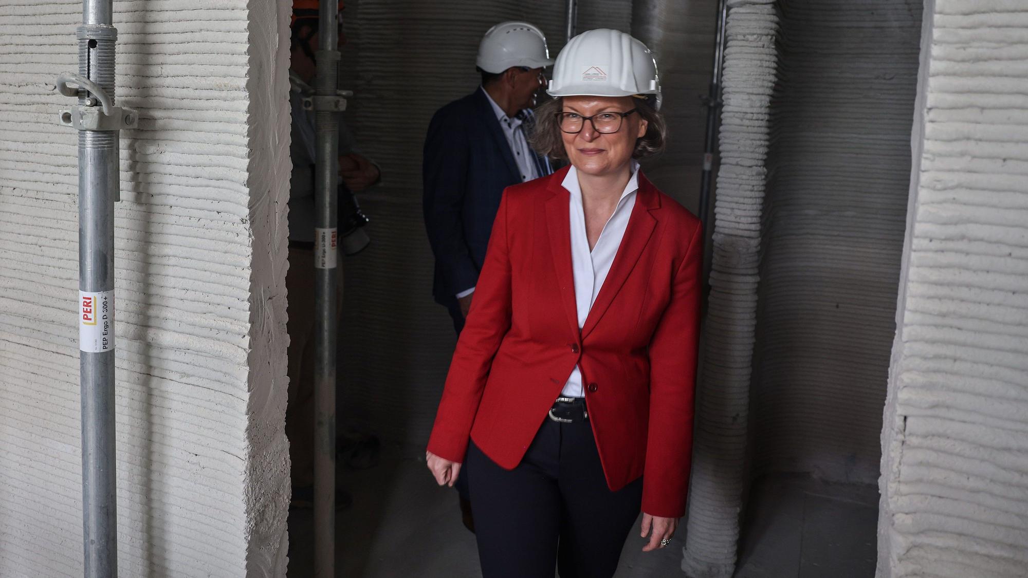 Ina Scharrenbach (CDU) geht durch die Baustelle von Europas erstem öffentlichen Gebäudes aus dem 3D-Drucker.
