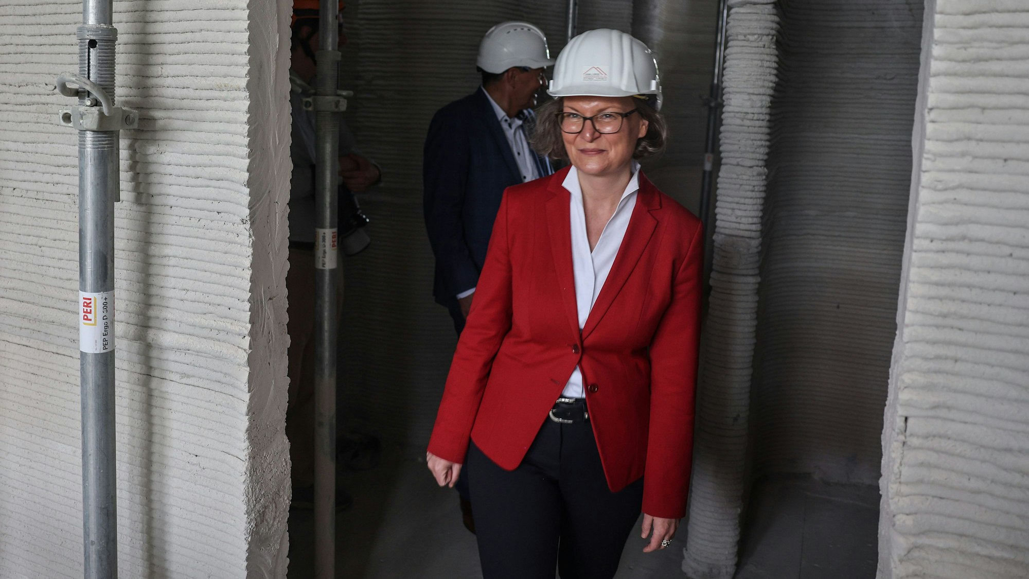 Ina Scharrenbach (CDU) geht durch die Baustelle von Europas erstem öffentlichen Gebäudes aus dem 3D-Drucker.