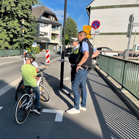 Polizist Andreas Weidemann und Bürgermeister Dirk Runge mit zwei Jungs auf dem Rad