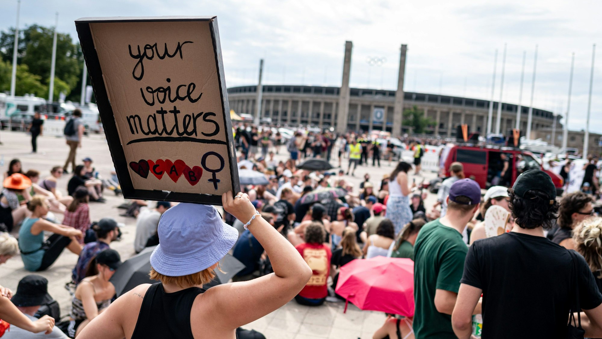 Eine Teilnehmerin der Demonstration Kein Rammstein-Konzert in Berlin! hält ein Schild mit der Aufschrift „Your voice matters“.
