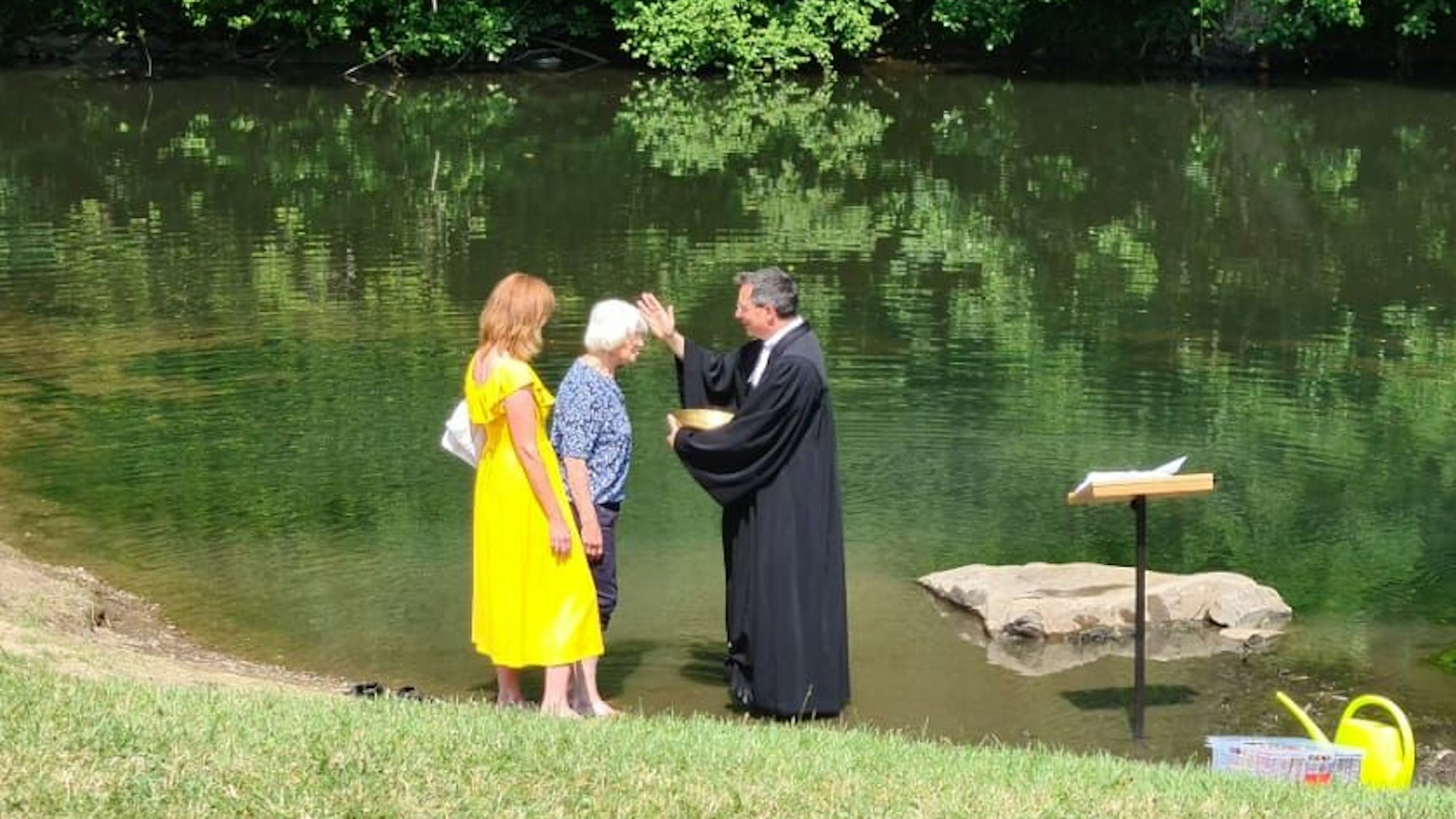 Die 83 Jahre alte Waltraud Geisen und ihre Tochter Birgit stehen am Ufer Agger. Dort nimmt Pfarrer Henning Strunk feierlich die Taufe vor.