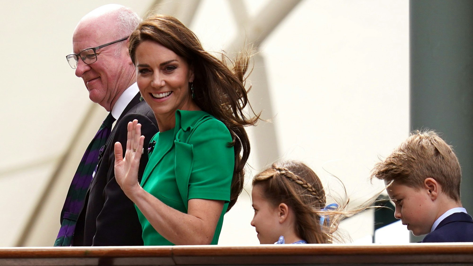 Prinzessin Kate, Prinz George und Prinzessin Charlotte werden vom AELTC-Vorsitzenden Ian Hewitt über die Spielerbrücke begleitet.