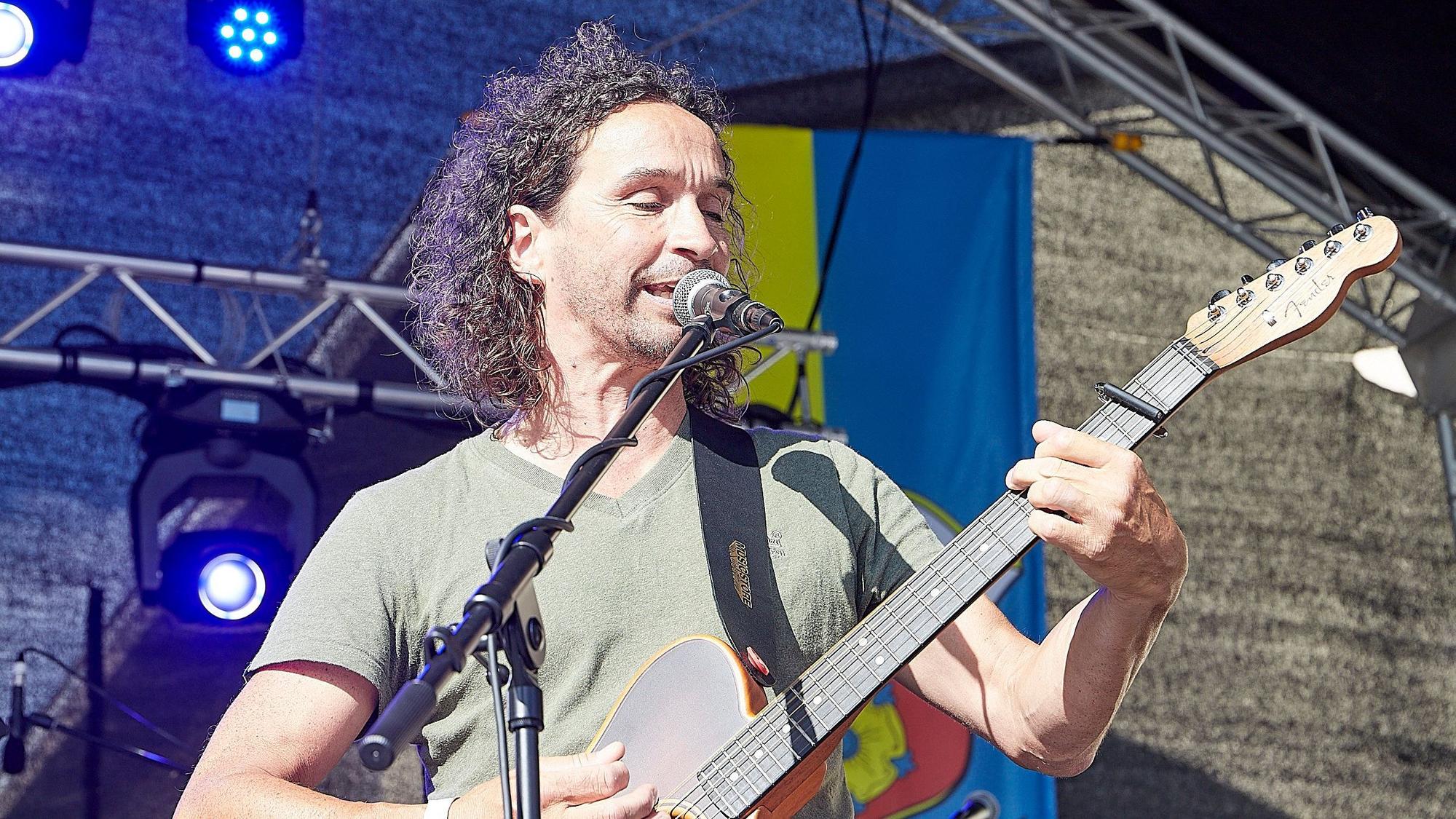 Ein Musiker spielt Gitarre und singt.