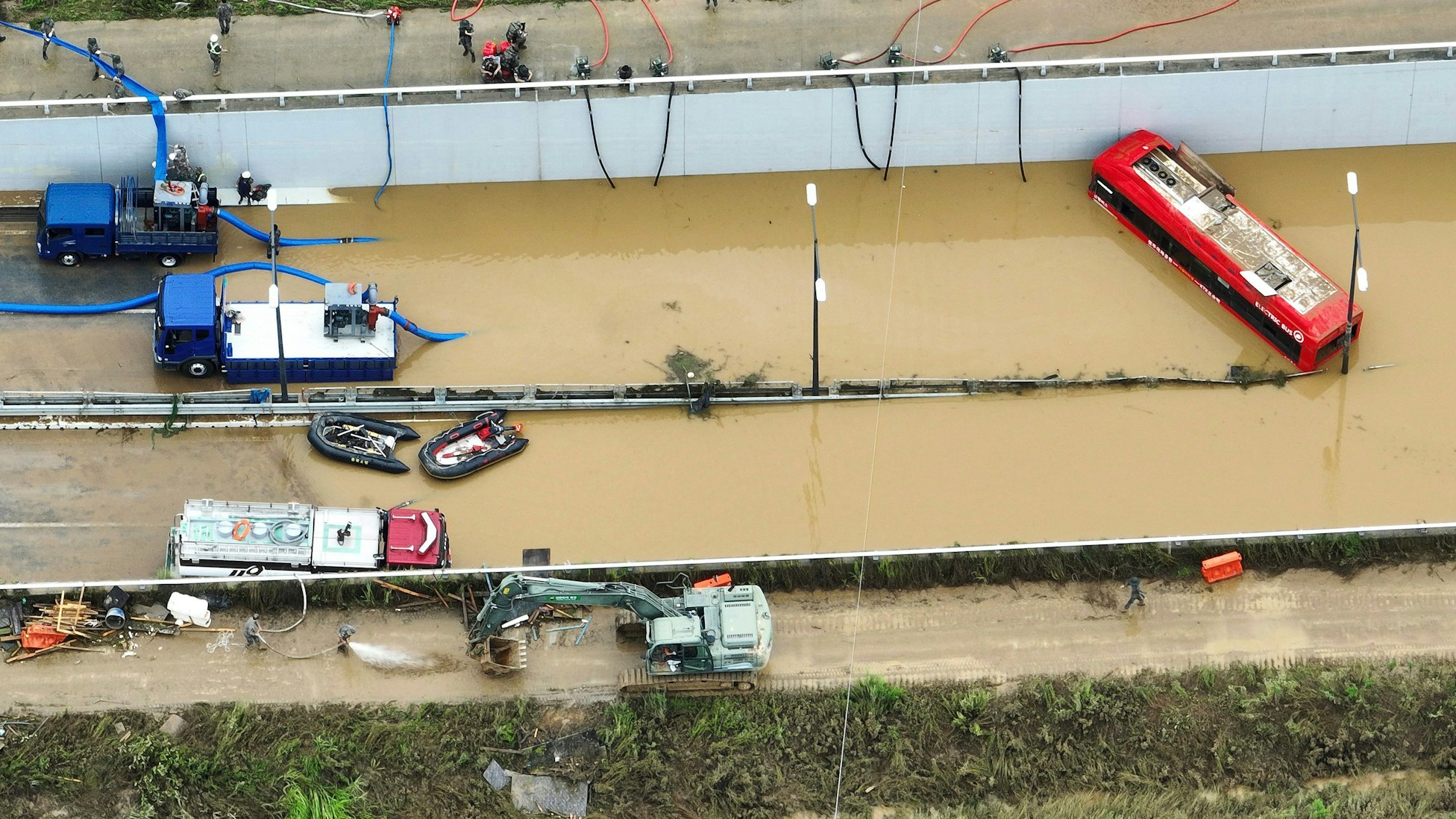 Rettungskräfte suchen nach Überlebenden auf einer Straße, die von Fluten überschwemmt wurde und zu einem unterirdischen Tunnel führt. Nach massiven Regenfällen und Überschwemmungen sind in Südkorea mehrere Menschen ums Leben gekommen.
