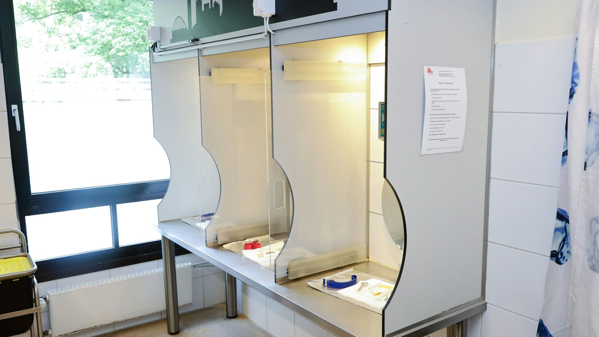 Auf einem Metalltisch sind drei Zellen voneinander abgetrennt. In jeder Zelle ist Material für einen sicheren, sterilen Konsum.