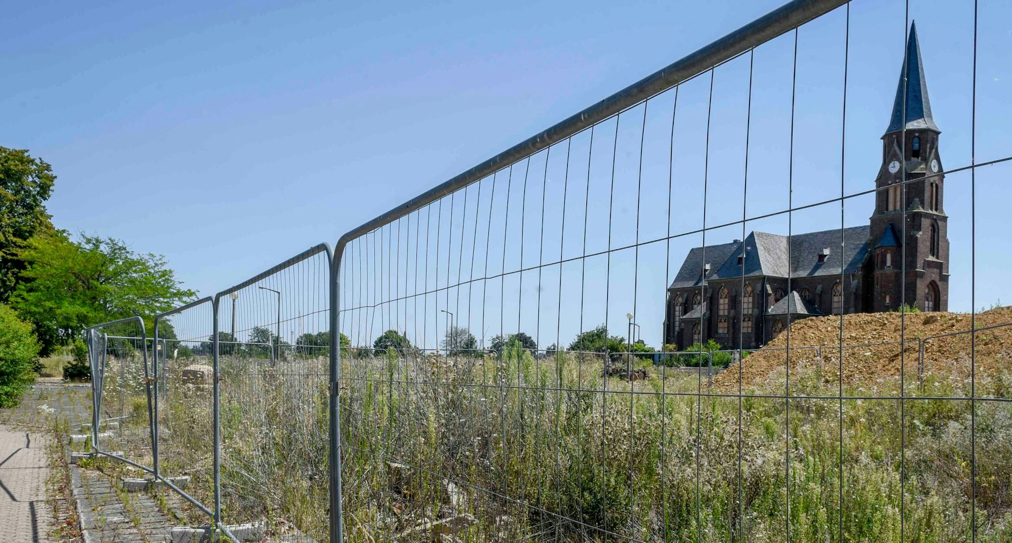 Auf dem Foto ist hinter einem Bauzaun die Kirche von Manheim-alt zu sehen.