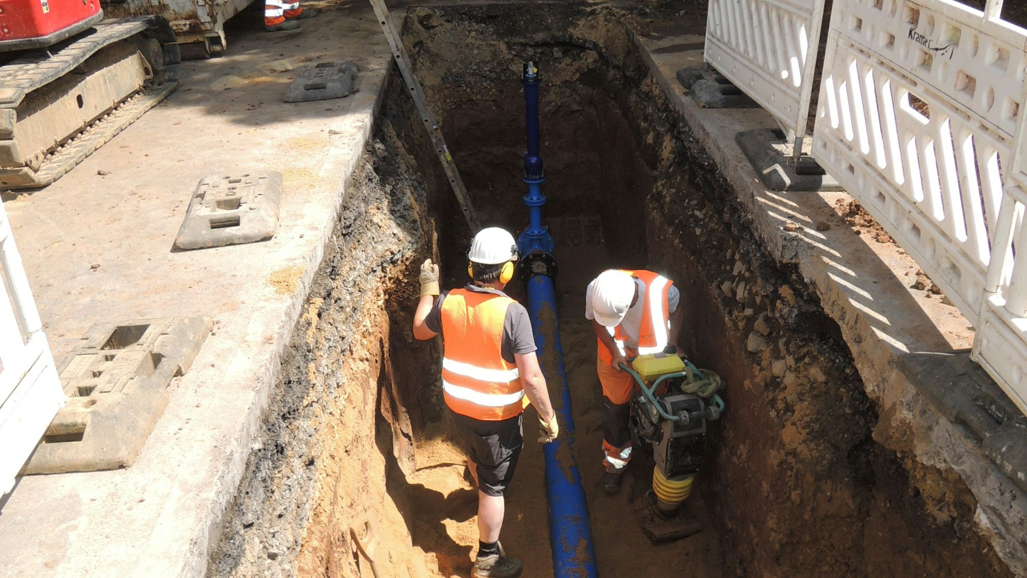 In der Nähe der Erftbrücke unter der Kölner Straße gab es einen Rohrbruch. Bauarbeiter stehen in einer zwei Meter tiefen Grube und reparieren den Schaden.