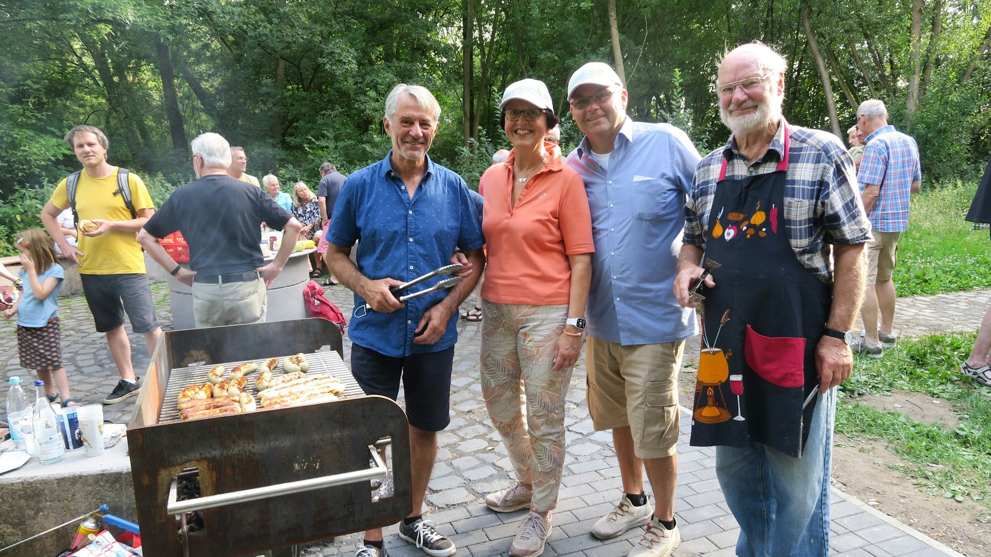 Die Verantwortlichen stehen an dem Grill.