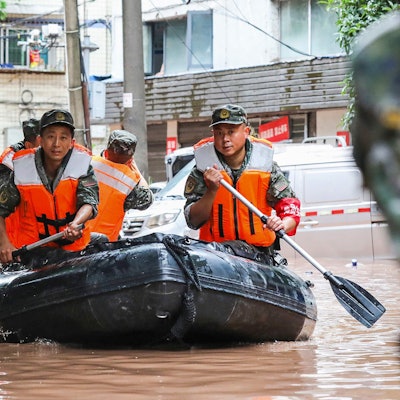 Paramilitärische Polizisten durchsuchen am 4. Juli 2023 im südwestchinesischen Chongqing ein Gebiet, das durch schwere Regenfälle überflutet wurde.
