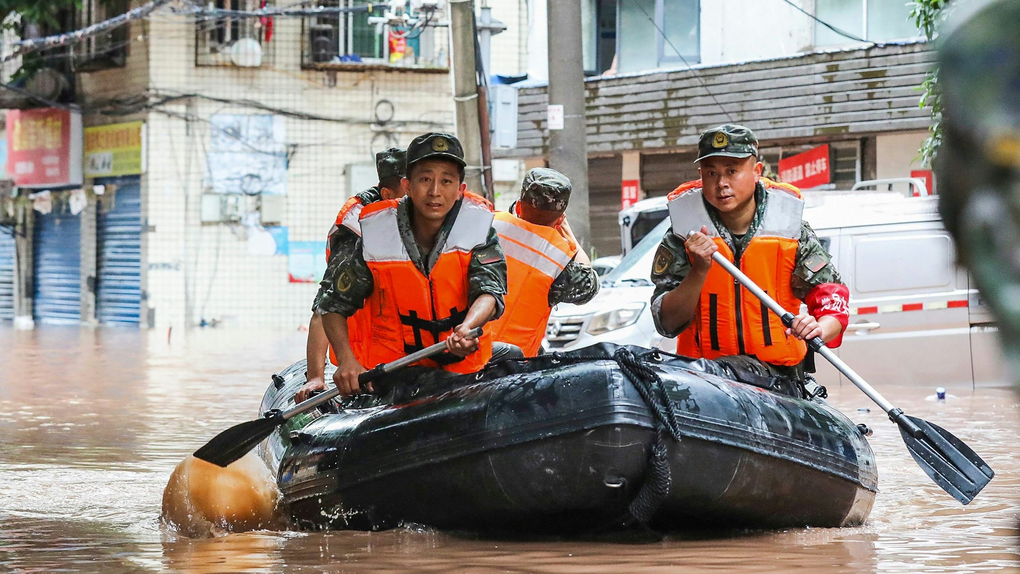 Paramilitärische Polizisten durchsuchen am 4. Juli 2023 im südwestchinesischen Chongqing ein Gebiet, das durch schwere Regenfälle überflutet wurde.
