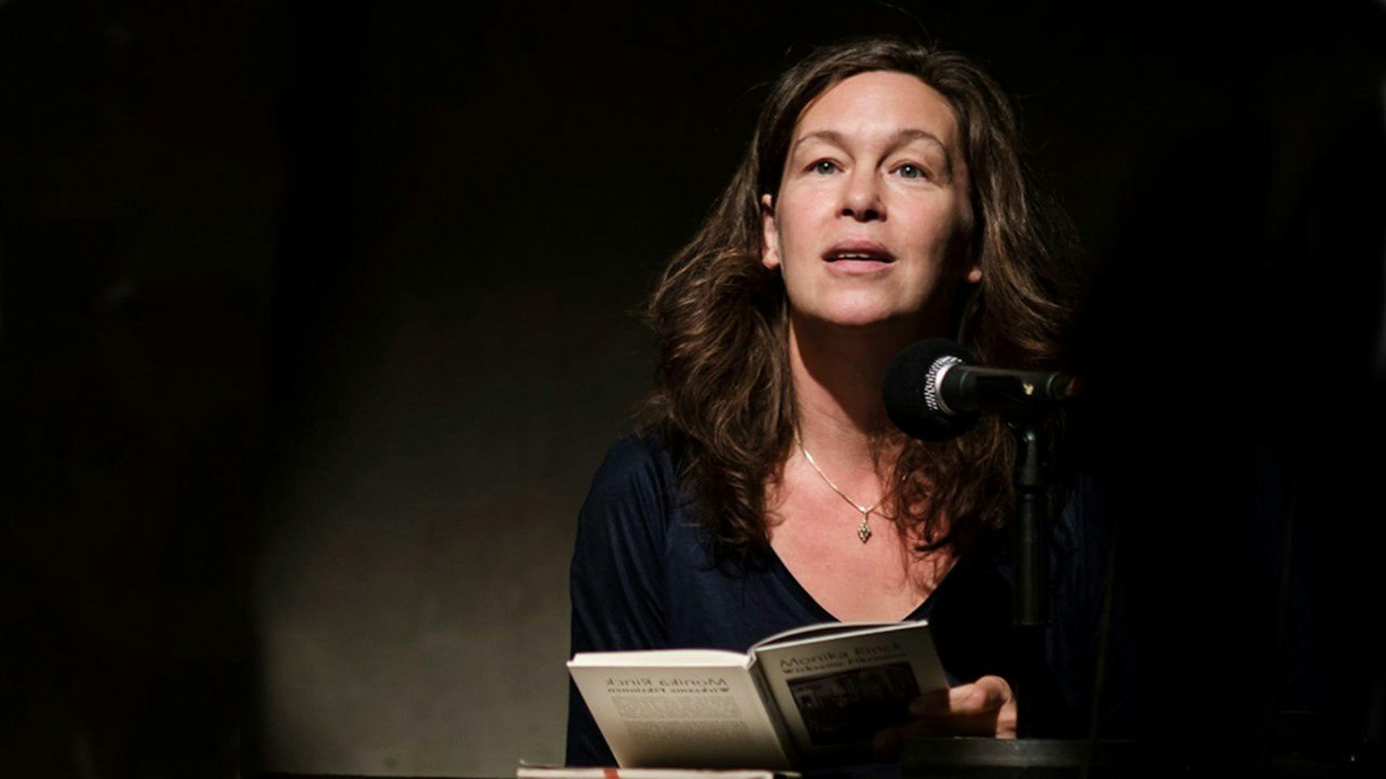 Monika Rinck liest aus einem Buch.
