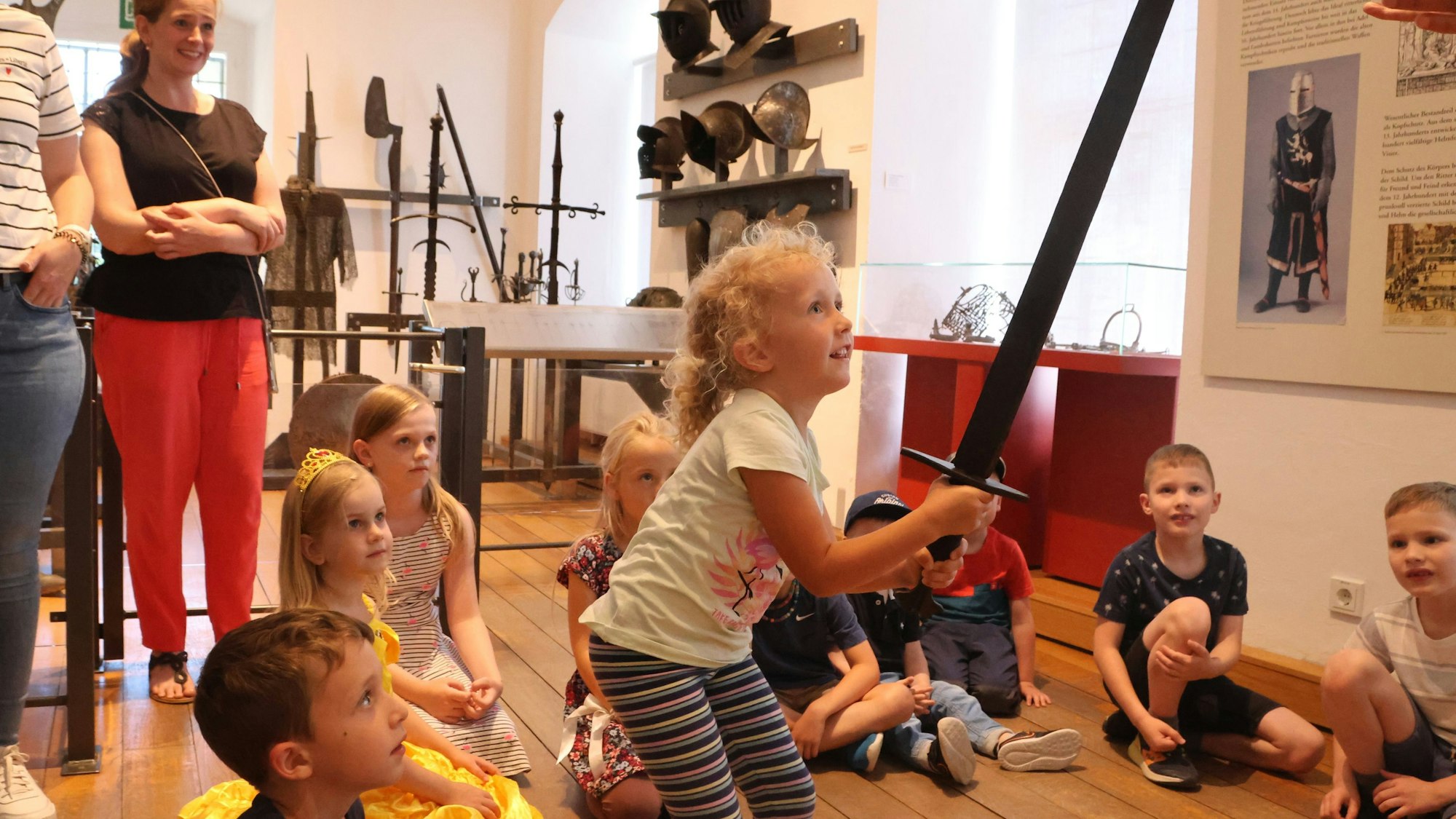 Ein Mädchen hebt ein Schwert in die Höhe.