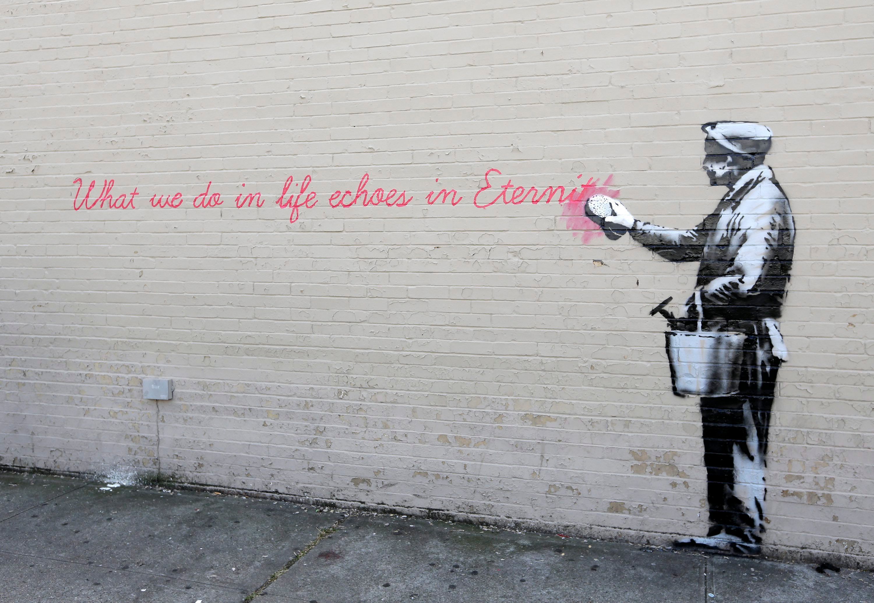 Ein Wandgemälde des britischen Straßenkünstlers Banksy mit der Aufschrift „What we do in life echoes in Eternity“ ist an einer Hauswand in Queens zu sehen.