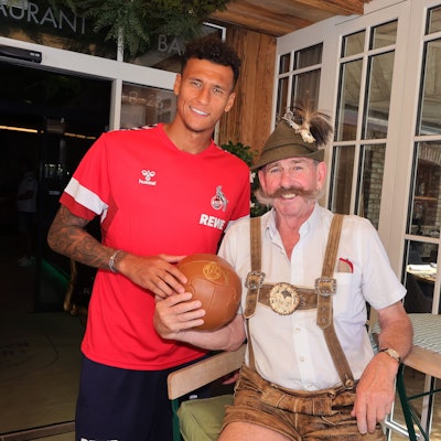 FC-Stürmer Davie Selke mit „Hangerl Hans", einem Original aus Maria Alm, vor dem Kölner Teamquartier Hotel Eder.
